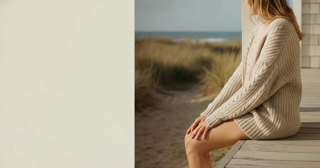 Woman in a chunky oatmeal knit sweater, sitting on the edge of a Hamptons clapboard porch