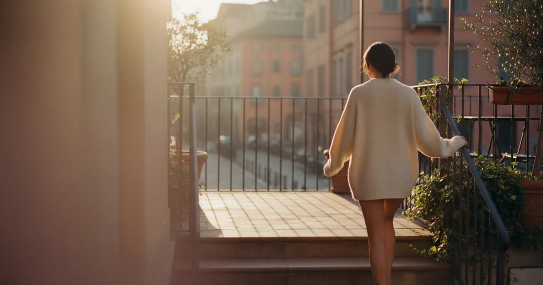 Woman in a chunky oatmeal knit sweater, stepping off a Milan trattoria terrace at sunset