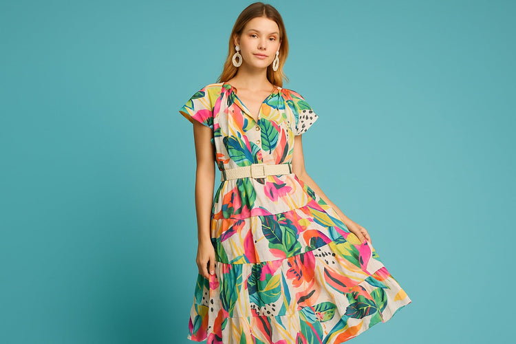 Woman twirling in a flowy midi dress in a sunlit outdoor setting.